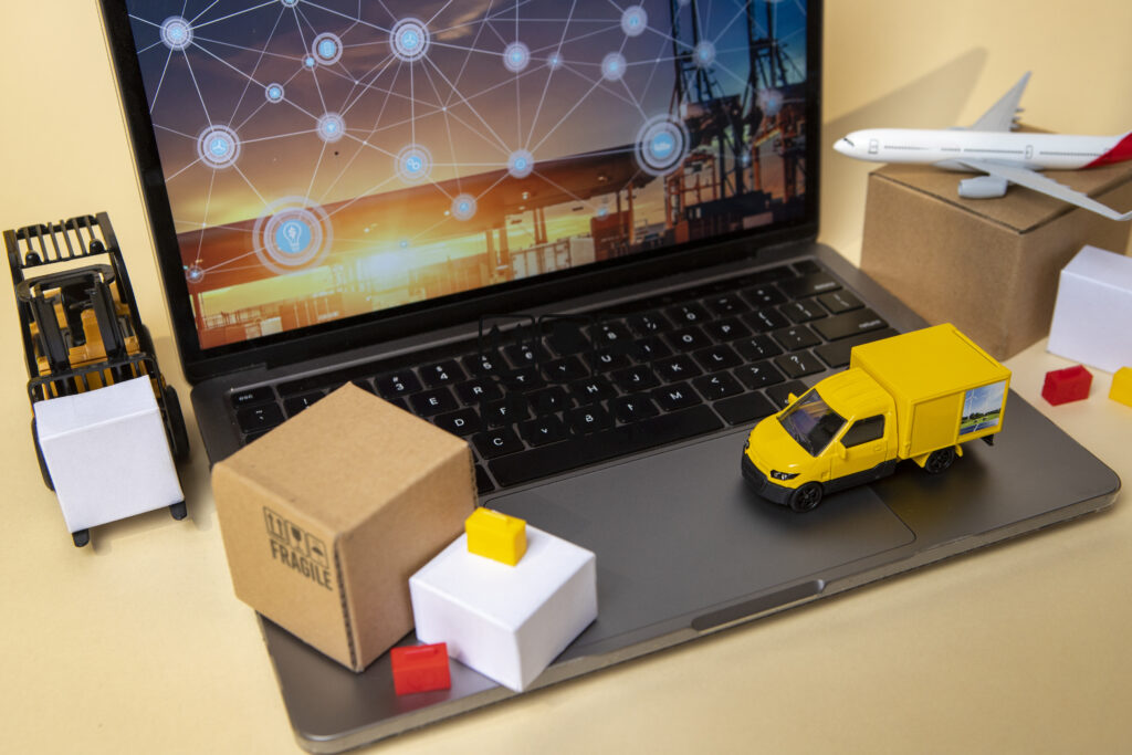 Laptop showing connected logistics tracking with delivery vehicles, parcels and air freight representing automated delivery updates